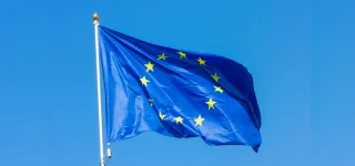 European Union flag waving in front of a blue sky